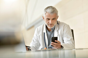 Fototapeta premium Portrait of doctor in hospital office working laptop