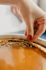 Woman decorating a homemade pumpkin cheesecake