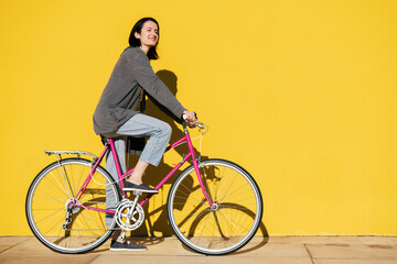 happy girl smiles riding her retro pink bike