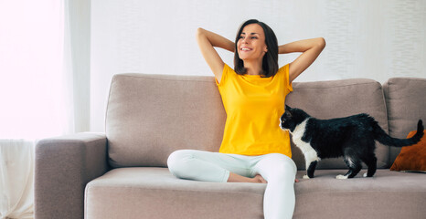 Beautiful calm confident brunette woman is resting on the couch at home during holidays