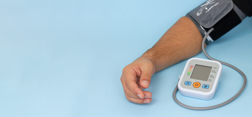 Man measures his blood pressure by electronic tonometer