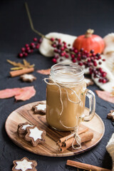 Pumpkin spiced latte or coffee in a cup on a turquoise vintage background. Autumn, fall, or winter hot drink. Cozy breakfast or snack.