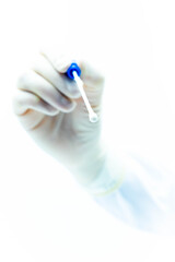 Hand of doctor with sterile gloves holding PCR test for covid-19 pointing at camera focus on tip, white background