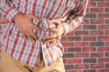 young man suffering stomach pain close up.