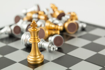 Golden and Silver chess surrounded by a number of fallen chess pieces, business strategy, chess battle, victory, success, teamwork concept. Chess on a chessboard. Chess board game.