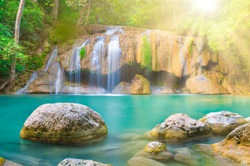 Tropical landscape with beautiful waterfall, emerald lake and rocks in wild jungle forest. Erawan National park, Kanchanaburi, Thailand