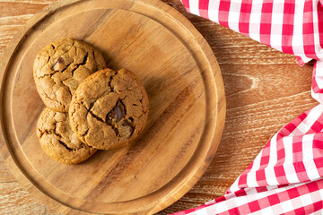 Delicious Homemade Chocolate Chip Cookies. Homemade chocolate cookies on wooden table background. cookies with dark chocolate chips on wooden plate. Fresh homemade cookies in a wooden plate.