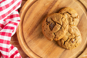 Delicious Homemade Chocolate Chip Cookies. Homemade chocolate cookies on wooden table background. cookies with dark chocolate chips on wooden plate. Fresh homemade cookies in a wooden plate.