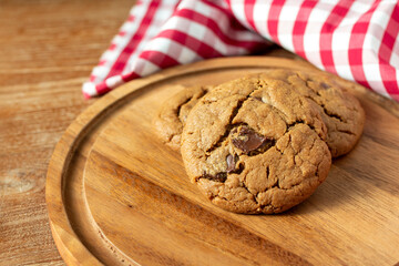 Delicious Homemade Chocolate Chip Cookies. Homemade chocolate cookies on wooden table background. cookies with dark chocolate chips on wooden plate. Fresh homemade cookies in a wooden plate.