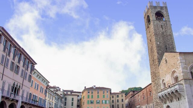 Time lapse of Paul VI place or square in Brescia, Italy during a sunny cloudy day. There is the saint maria assunta old romanic stone bricks cathedral on the right