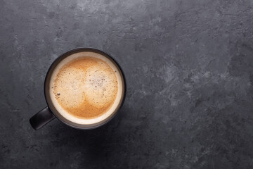 Cup cup of fresh coffee on on dark stone background. Top view. Copy space for your text
