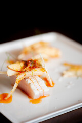 Hamachi or yellowtail sashimi. Fresh Sushi and sashimi pieces: tuna, mackerel, yellowtail, salmon and uni. Classic Japanese Izakaya cuisine, raw fish with sticky rice, wasabi and pickled ginger