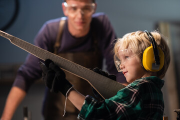 the older brother helped the younger one make weapons out of wood and the younger one plays in the carpentry shop