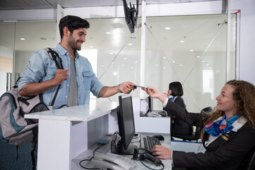 Airline passengers checking in at airline counter.