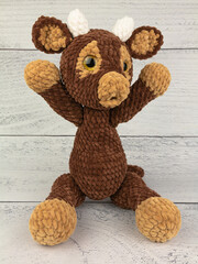 Plush bull toy on a wooden background. The symbol of the 2021 new year.
