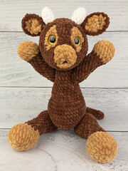 Plush bull toy on a wooden background. The symbol of the 2021 new year.