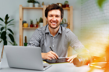 Smiling man photographer or retoucher working from home