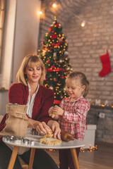 Mother and daughter kneading dough for Christmas cookies