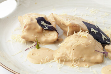 Dumplings or vareniki with mushroom sauce isolated on white