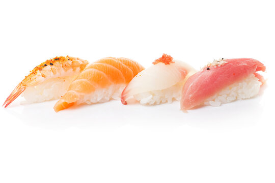 Four fresh sushi bites. Studio photo isolated on white background on reflective surface. Bright light setting.