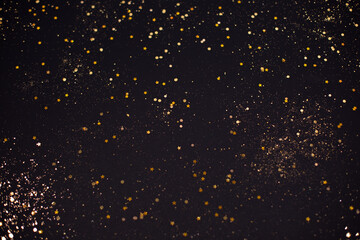 Fototapeta na wymiar Christmas Gold glitter on black background. Holiday abstract