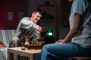 Date in an intimate setting of a tea house. A man and a woman drink fragrant tea together. Mysterious oriental tea ceremony