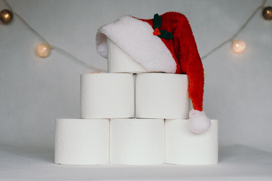 covid christmas tree from toilet paper with santa claus hat on toilet paper rolls on white background
