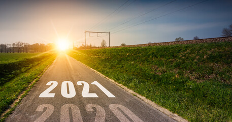 New Year's concept with year 2021 printed in the middle of an asphalt road at sunset. Way to...