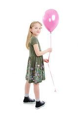 Full length. Playful little girl holding pink balloon. Isolated on white background.
