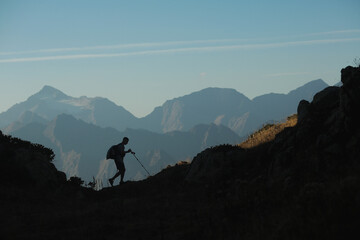 man with hiking poles in the mountains