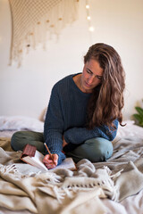 Woman journaling whilst sat on bed