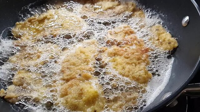 Frying a wiener schnitzels in pan.