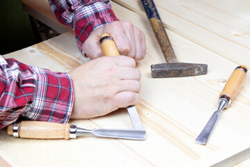 Chisels. Work of carpenter. Handyman with tools.Assortment of chisel of wood for carpentry. Hand holding chisel