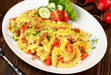 Cheesy Noodle Omelette with Tomato and Bacon on wooden Background