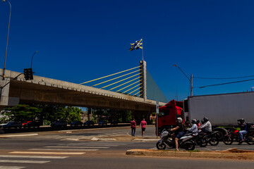 Fototapeta premium Viaduto Estaiado na cidade de Anápolis em Goiás. Viaduto com uma bandeira da cidade de Anápolis com céu azul ao fundo.