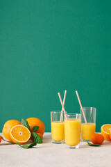 Freshly squeezed orange juice in a glasses with straws and fresh fruits with leaves, healthy drink,...