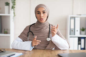 Woman in hijab doctor explaining diagnosis to patient - obrazy, fototapety, plakaty