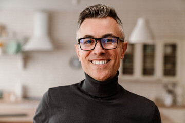 Obraz premium Handsome happy man in eyeglasses smiling at camera