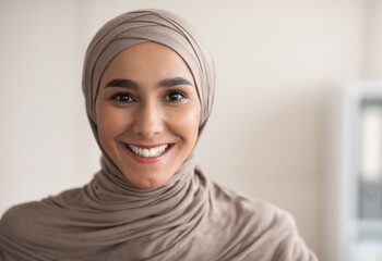 Portrait of cheerful woman in hijab over clinic interior - obrazy, fototapety, plakaty