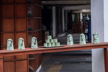 teapots and green enamel glasses displayed in front of the coffee shop in front of the hallway