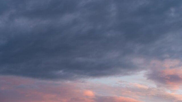 Fast moving dark clouds background. Time lapse shot of storm clouds at sunset