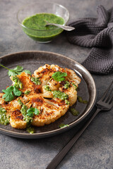 cauliflower steaks with herb sauce and spice. plant based meat substitute