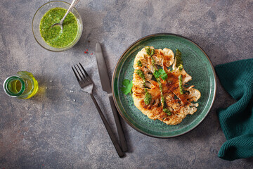 cauliflower steaks with herb sauce and spice. plant based meat substitute