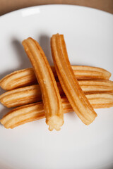 Various churros on a plate on white background. Vertical image.