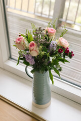 mid side angled view of bouquet blue vase handle ceramic of rose flowers bunch pink green purple macro close up vertical