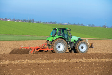 Traktor mit Egge auf einem Acker