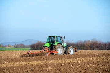 Traktor mit Egge auf einem Acker