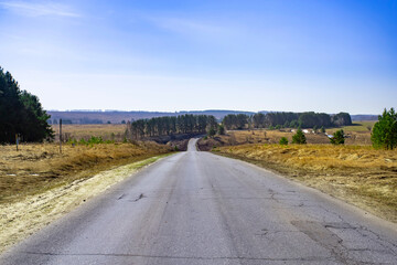 Asphalt road going through the countryside going into the distance.