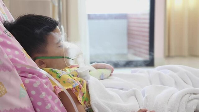 Asian little boy making inhalation with nebulizer at hospital, Nebulization concept