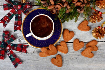 Coffee cup with gingerbread cookies on table and Christmas decorations